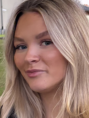 Blond kvinna ler in i kameran